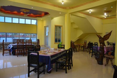 a dining room with a long table and chairs at BBL Resort in Bokākhāt