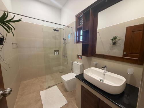 a bathroom with a sink and a shower and a toilet at Sky and Sand Guesthouse in Beruwala