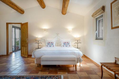 a bedroom with a large white bed with pillows at Benvengudo in Les Baux-de-Provence