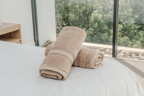 a rolled up towel on a bed with a window at On Flinders Wollongong in Wollongong