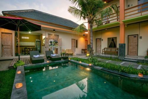 a villa with a swimming pool in front of a house at The Rani Garden Bed & Breakfast in Denpasar