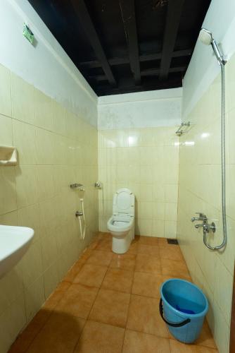a bathroom with a toilet and a sink at Chandralayam Heritage Homestay in Bekal