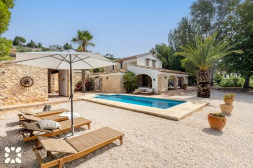 a villa with a swimming pool and an umbrella at Villa Fantaxat by Abahana Villas in Benissa