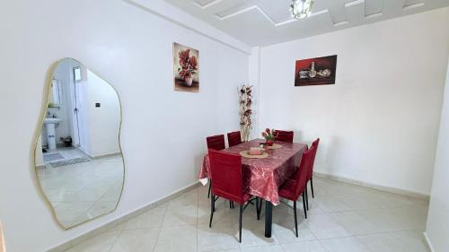 a dining room with a table and a mirror at marhaba apartement in Oujda