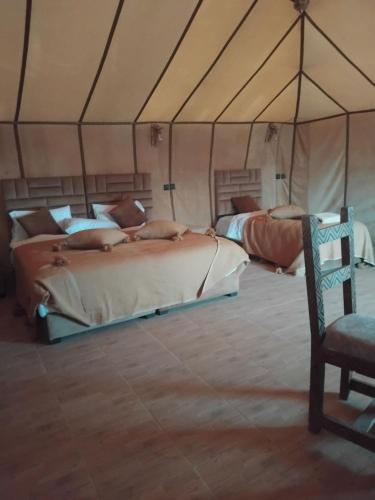 a bedroom with two beds in a tent at Merzouga camelle trike bivoage in Merzouga