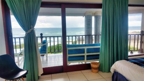 a bedroom with a view of the ocean from a balcony at The View in Port Alfred