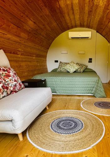 a bedroom with a bed and a couch in a room at Botte dei Benandanti in Vivaro