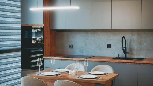 a kitchen with a wooden table and white cabinets at Synyogora in Yaremche