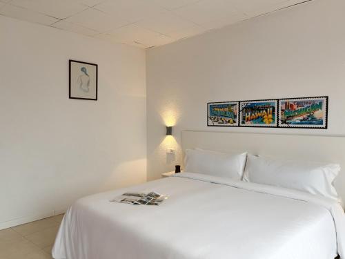 a bedroom with a white bed with a magazine on it at Hotel Las Vegas in Calella