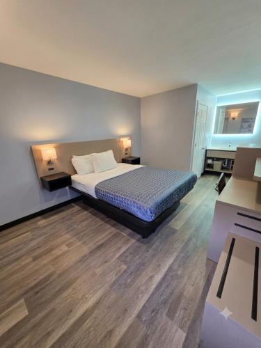 a bedroom with a bed and a wooden floor at Rodeway Inn Sandusky North in Sandusky