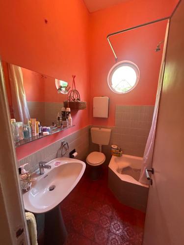 an orange bathroom with a sink and a toilet at Villino Arsella in Marina di Pietrasanta