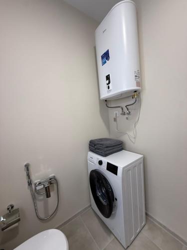 a bathroom with a washing machine and a toilet at Морской Двор in Chornomorsk