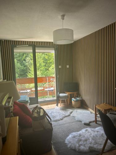 a living room with a couch and a balcony at B&B cot in La Ferrière