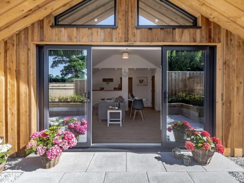 an open glass door of a house with flowers at Olchard Lodge in Newton Abbot