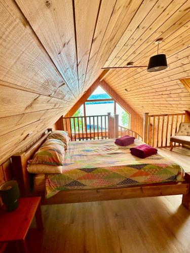 a bed in a room with a wooden ceiling at Lochside Lodge in Dallavich