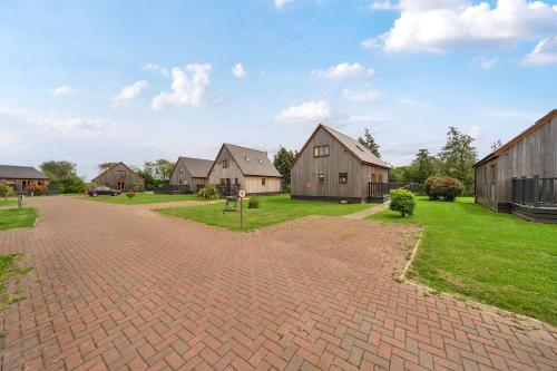a brick driveway in a yard with houses at Pumpkin Lodge in Brigg