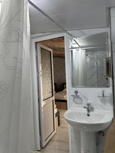 a bathroom with a sink and a mirror at Гостевой дом Sartepo in Samarkand