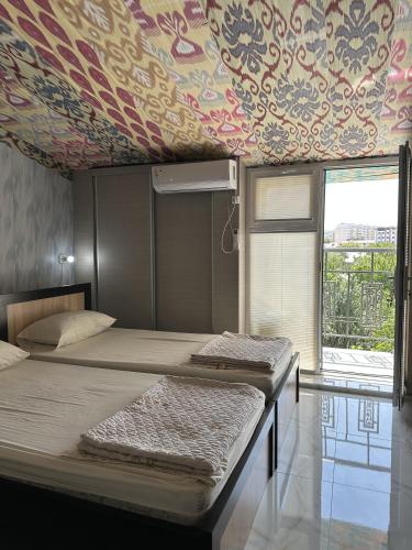 two beds in a room with a wallpaper at Гостевой дом Sartepo in Samarkand