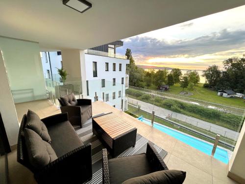 a living room with couches and a view of a pool at Helikon Terasz Apartman in Keszthely