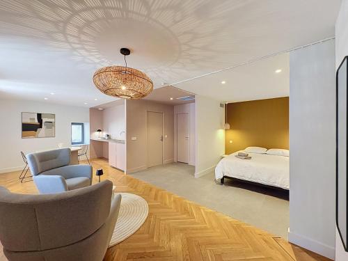 a bedroom with a bed and a chandelier at Maison 65 in Pierrelatte