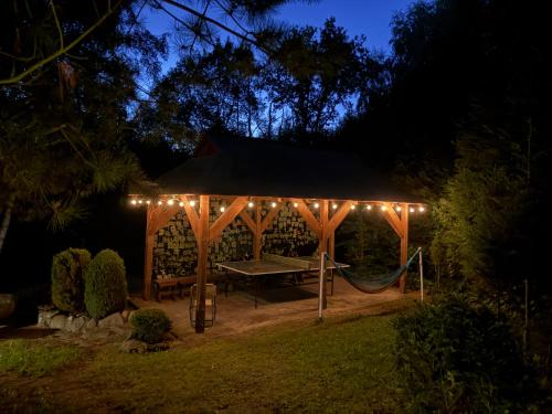 a picnic table in a gazebo at night at Zacisze Zygmuntowo in Zygmuntowo