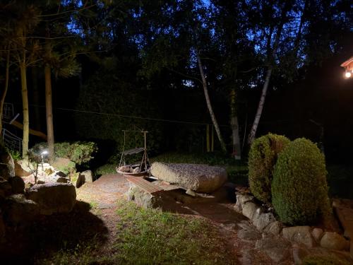 a garden at night with a bench and trees at Zacisze Zygmuntowo in Zygmuntowo