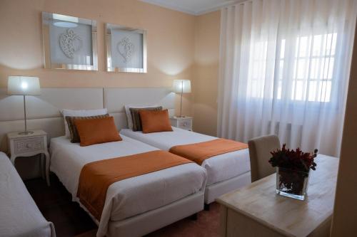 a hotel room with two beds and a window at Telesico Residencia in Pombal