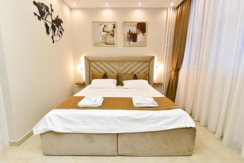 a bedroom with a bed with two towels on it at Dream Palace 1 in Belgrade
