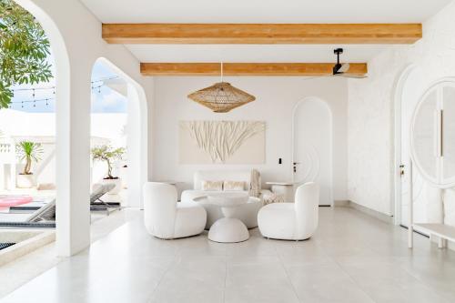 a living room with white furniture and a table and chairs at Casa Contenta Canggu - Luxury 5BR Private Pool Villa in Canggu