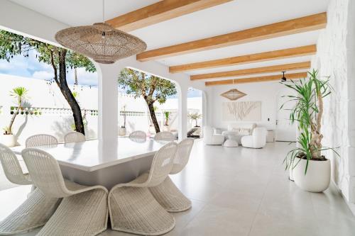 a dining room with a white table and chairs at Casa Contenta Canggu - Luxury 5BR Private Pool Villa in Canggu