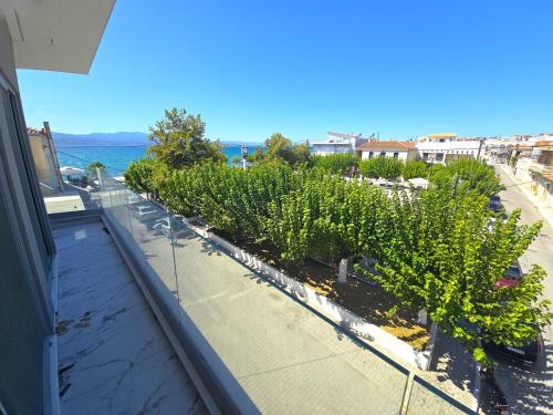 a balcony with a row of trees and the ocean at Evia Plaza Suites in Amarynthos
