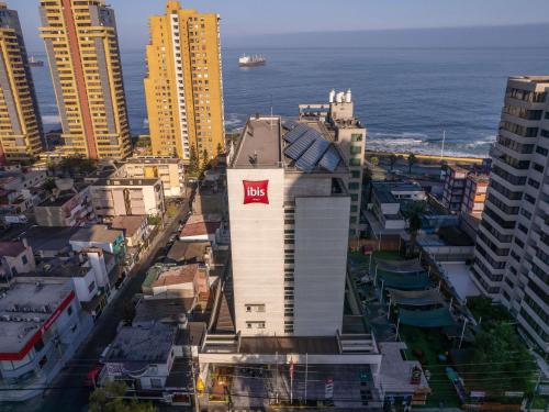 a tall white building with a m hotel sign on it at ibis Antofagasta in Antofagasta