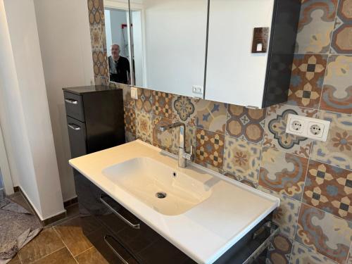 a bathroom with a sink and a mirror at Stangenberg`s City Loft in Hameln