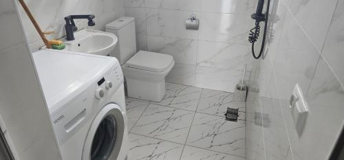 a bathroom with a washing machine and a sink at Rokiti Yard in Bagdatʼi