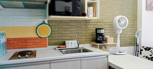 a kitchen with a sink and a microwave at Beautiful Sandy Jomtien Beach Pattaya at NeO Seaview Condo in Jomtien Beach