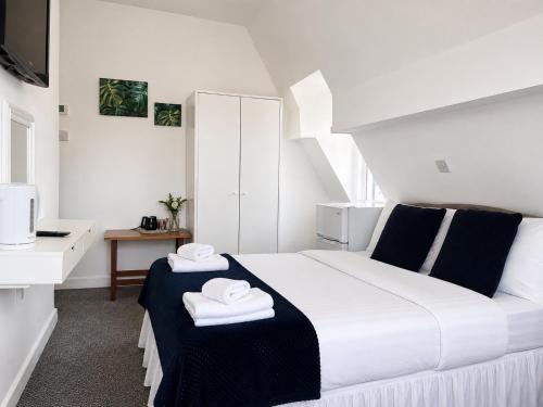 a bedroom with a bed with two towels on it at Alexandra Hotel Blackpool in Blackpool