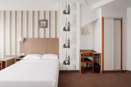 a bedroom with a white bed and a desk and a table at Get My Hatch Bergère in Paris