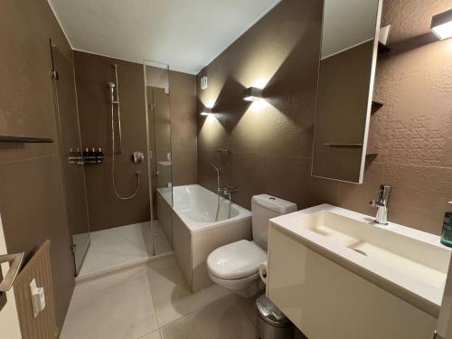 a bathroom with a toilet and a shower and a sink at Slope-Side Mountain Apt Sleeps 4 in Laax