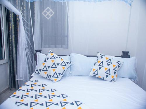 a bedroom with a bed with pillows on it at Queen Tori in Malindi