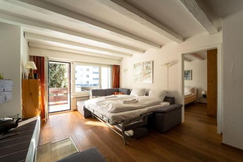 a bedroom with a bed and a couch and a window at Slope-Side Mountain Apt Sleeps 4 in Laax