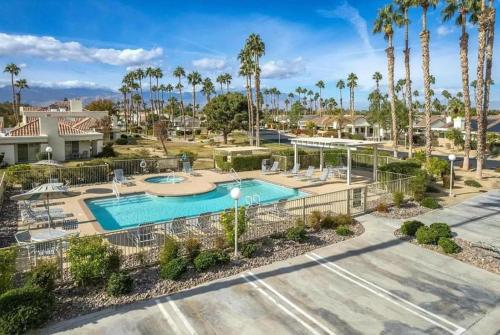 a pool at a resort with palm trees at Desert Breezes Resort in Palm Desert