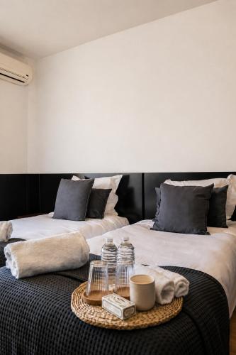 two beds in a room with a tray on a table at Hôtel Gallia Cannes in Cannes