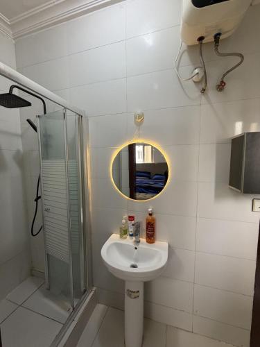 a bathroom with a sink and a shower and a mirror at The Luxe Haven in Lekki Phase 1