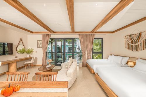 a bedroom with a bed and a living room at Maison Thu in Phú Quốc