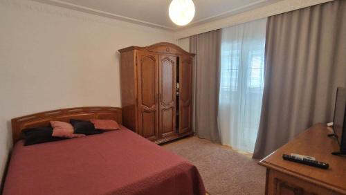 a bedroom with a bed and a wooden cabinet at Apartament ALBATROS in Mangalia