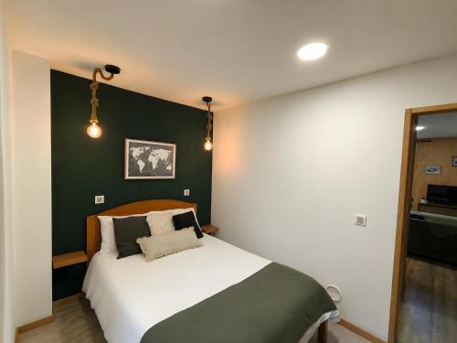 a bedroom with a bed with a green accent wall at Casa Wood in Guarda