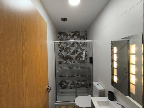 a bathroom with a shower and a toilet and a sink at Casa Wood in Guarda