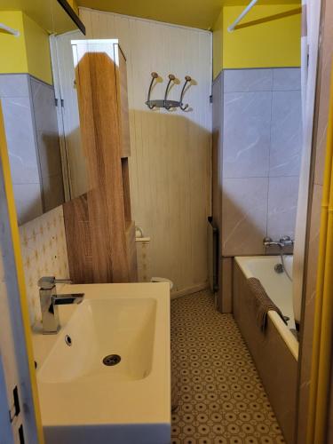 a bathroom with a sink and a tub and a toilet at Studio Le Boussolenc in Les Orres