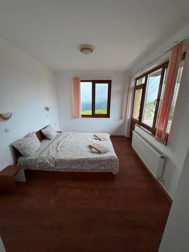 a bedroom with a bed and two windows at Guest House Chala in Chala