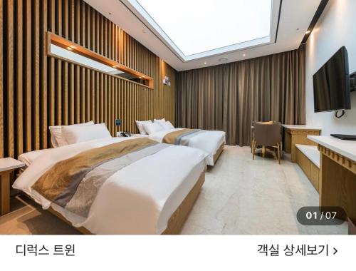 a hotel room with two beds and a television at 호텔뷰 in Tomin-dong